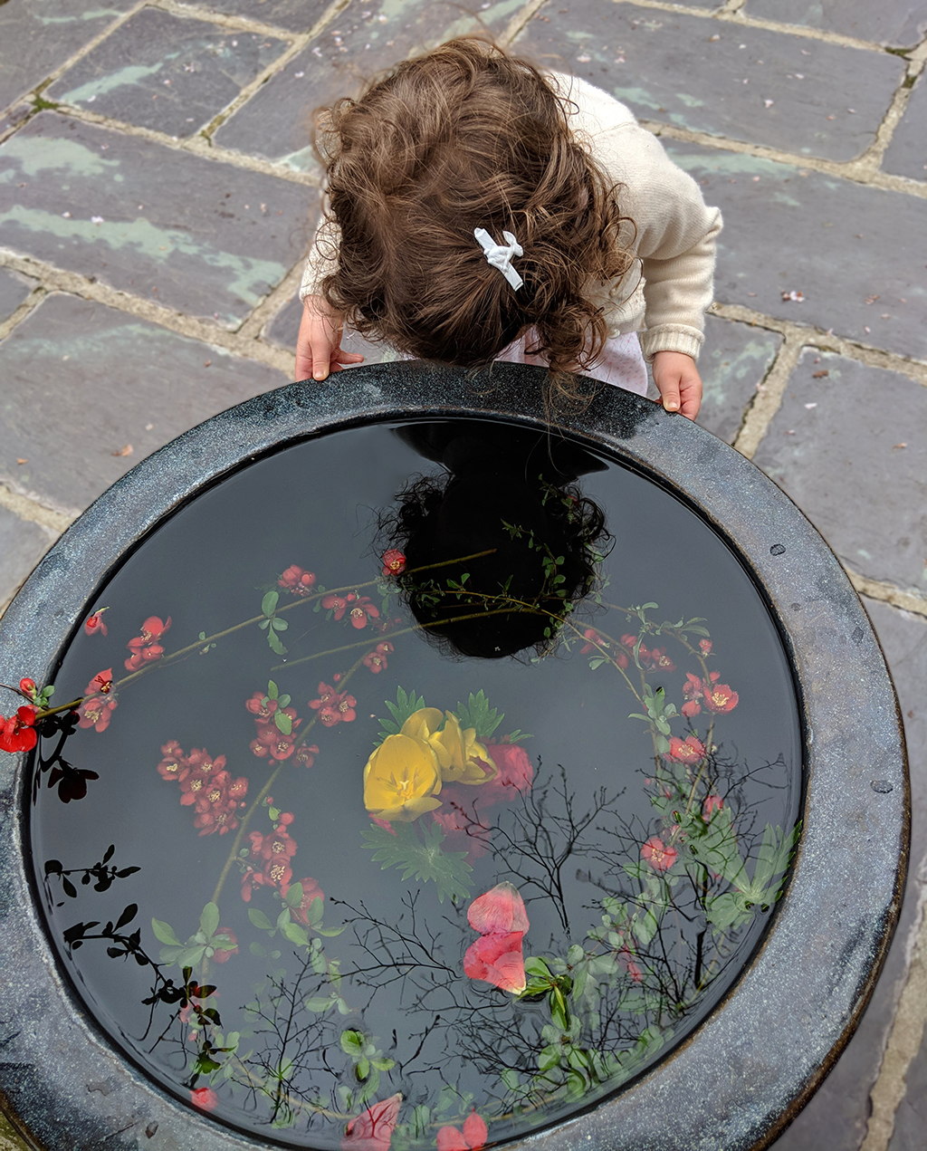 Girl Looking In Reflected Water In Pot